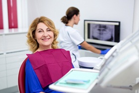 middle-aged woman smiling in dental chair 
