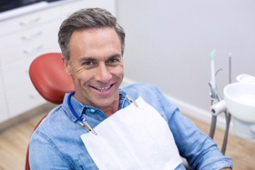 middle-aged man smiling in dental chair 