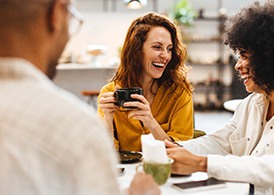 Group of friends smiling while enjoying coffee