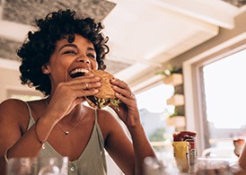 Woman smiling while eating at restaurant